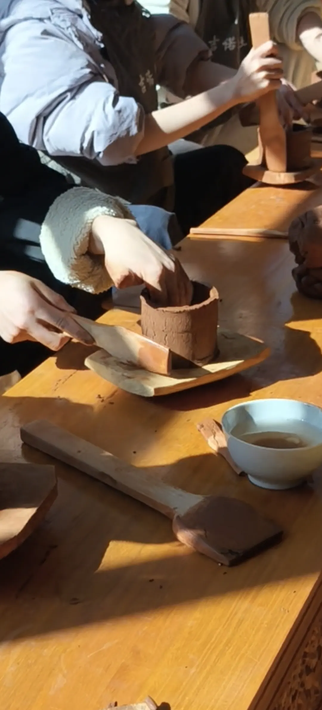 匠人以双手修整陶坯